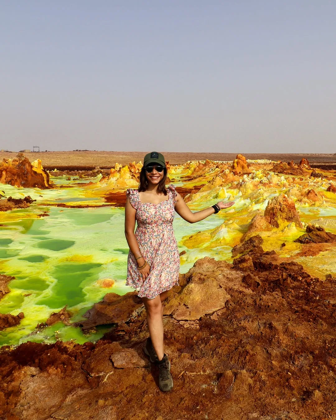 Traveller standing beside colourful mineral formations at Dallol in Ethiopia